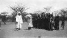 Řada dívek tleskajících do taktu a tři muži v bílých galábijích, kmen Hamayd, společenství Baggara
