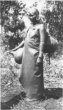 Stojící dívka v koženém přehozu a s nádobami z tykve