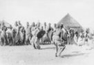 Dva muži se štíty a biči tančí před řadou mužů