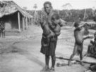 Žena kouřící dýmku, na boku drží dítě zavěšené v pruhu kůže, Bambuti