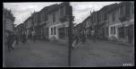 Dvojsnímek. Pohled na ulici s tradiční patrovou zástavbou, v popředí skupina procházejících mužů