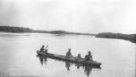 Čtyři muži v člunu vydlabaném z jednoho kmene