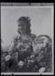 Fotografie, usmívající se žena sbírá růžové květy do košíku