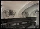 Pestrá výplň kolem dvou obrázků (Masaryk) a dřevěného kříže čp. 153. Maj. Josef Fašing (?), klenba, stůl, lavice