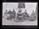 Sedící ženy před domem, šest žen a malý hošík