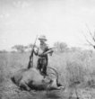 Machulka s puškou nad ulovenou antilopou
