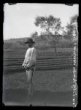 Postava muže – gorala – mladého v klobouku, pohled z profilu, stojí u ohrady pro dobytek.