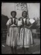 Dvě dívky v polo svátečním kroji s úvazy z lipského šátku na hlavě