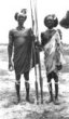 Dva muži s kloboukovitými účesy, v rukou drží oštěpy, Šilukové