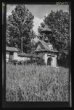 Klenutá branka na hřbitov v podobě domku se sedlovou střechou, na jejímž hřebeni je zvonička