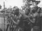Skupina mužů napjatě sledujících závody, Bambuti