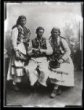 Mladý muž se dvěma ženami v tradičních svátečních krojích, ateliérové foto.