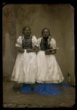 Dvě dívky v polo svátečních krojích, vlasy stažené do účesu v týle, v rukou drží modlitební knihy - ateliérové foto